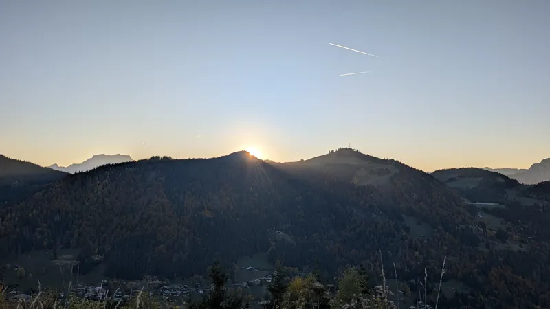 Mostly clear sky sunset over mountain silhouettes