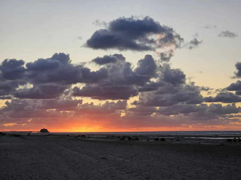 Scattered cumulus clouds with warm color at a beach sunset